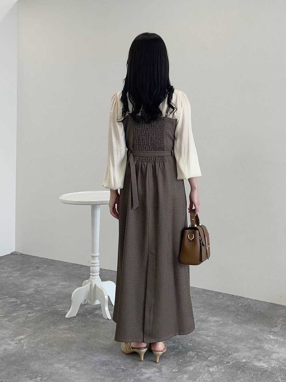 ゴールド系のパンプス、ブラウン系のショルダーバッグ、ホワイト系のシャツ/ブラウスを着用したレディースの秋コーディネートの4枚目の写真