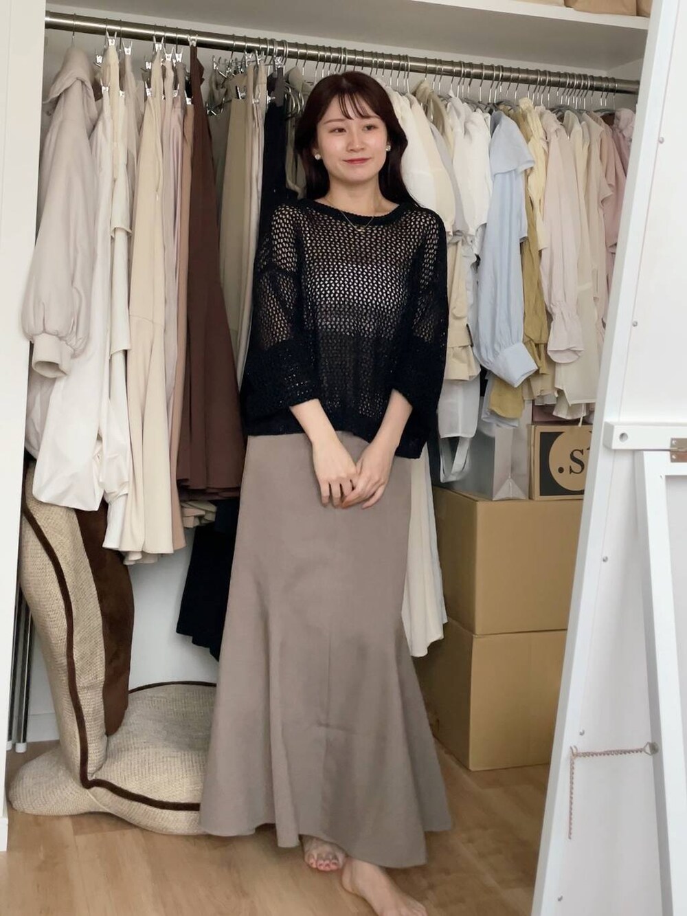 ブラック系のニット/セーター、ベージュ系のスカートを着用したレディースの夏コーディネートの2枚目の写真