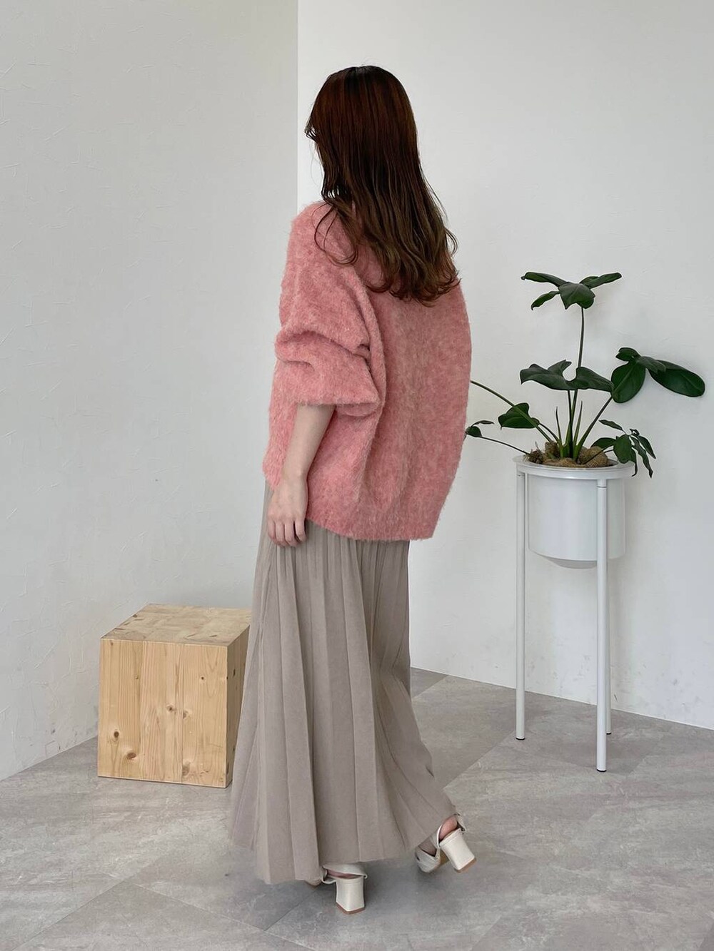 ホワイト系のハンドバッグ、オレンジ系のカーディガン/ボレロ、ホワイト系のパンプスを着用したレディースの秋コーディネートの2枚目の写真