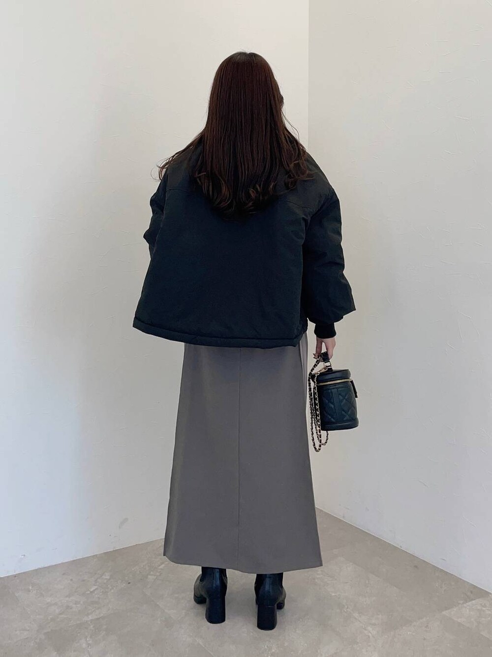 ブラック系のブーツ、ブラック系のブルゾン、ブラック系のショルダーバッグを着用したレディースの冬コーディネートの2枚目の写真