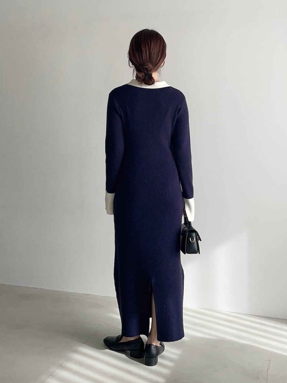 ブラック系のローファー、ブラック系のショルダーバッグ、ブルー系のワンピースを着用したレディースの冬コーディネートの2枚目の写真