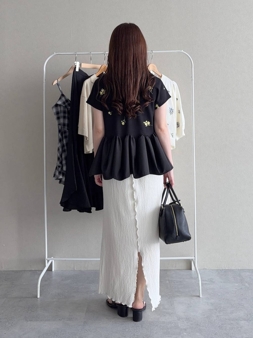 その他のTシャツ/カットソー、ホワイト系のスカート、ブラック系のハンドバッグを着用したレディースの夏コーディネートの2枚目の写真