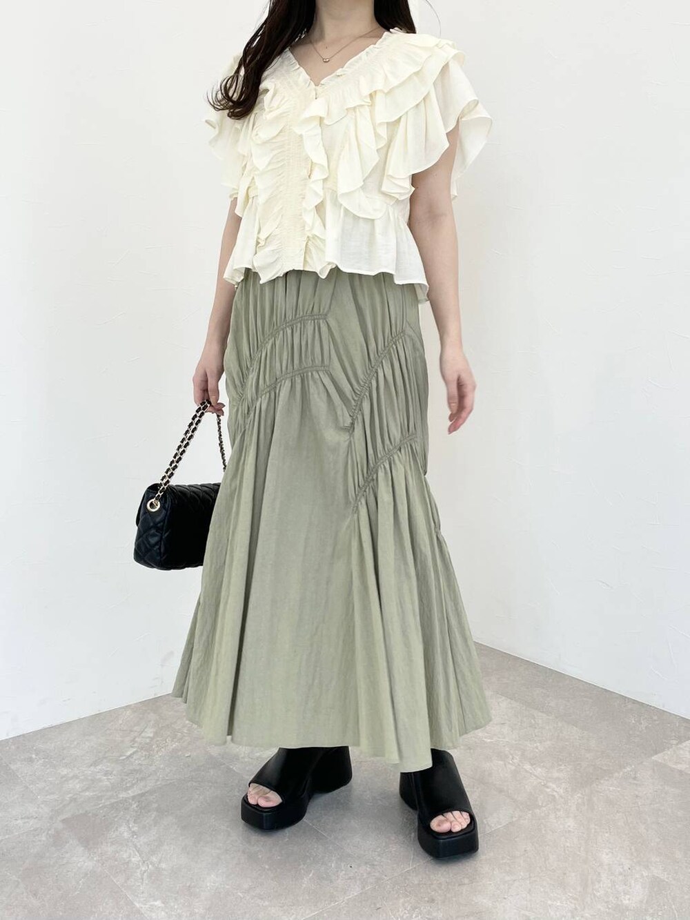 ブラック系のサンダル、ホワイト系のシャツ/ブラウス、ブラック系のショルダーバッグを着用したレディースの春コーディネートの4枚目の写真