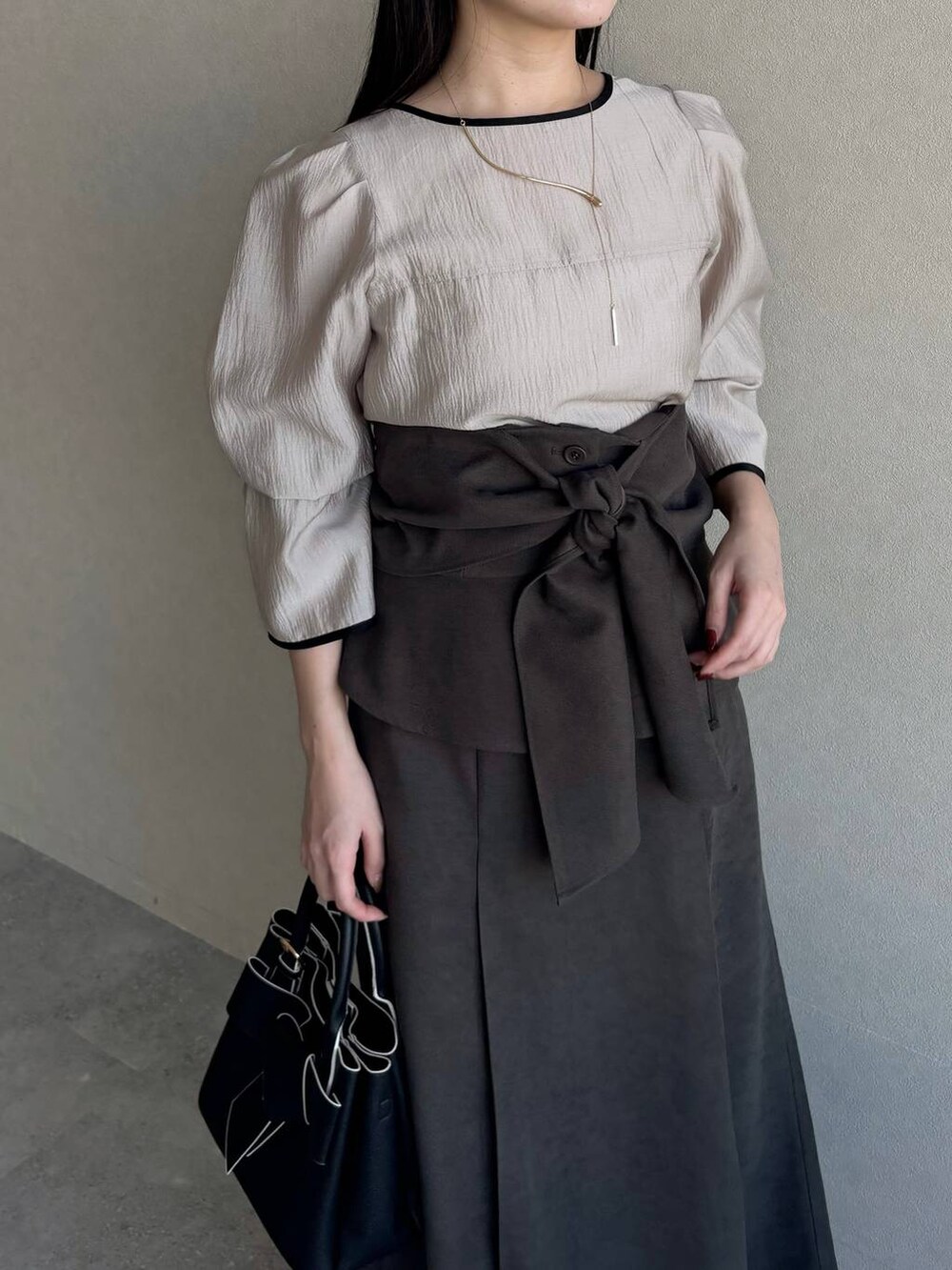 ホワイト系のブーツ、ブラック系のショルダーバッグ、ベージュ系のシャツ/ブラウスを着用したレディースの冬コーディネートの5枚目の写真