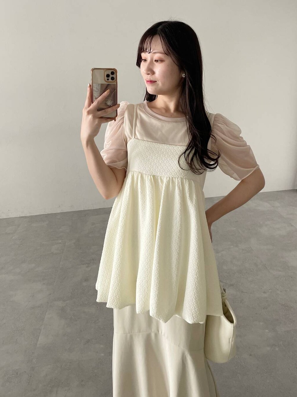 ホワイト系のハンドバッグ、ホワイト系のスカート、ホワイト系のサンダルを着用したレディースの春コーディネートの4枚目の写真