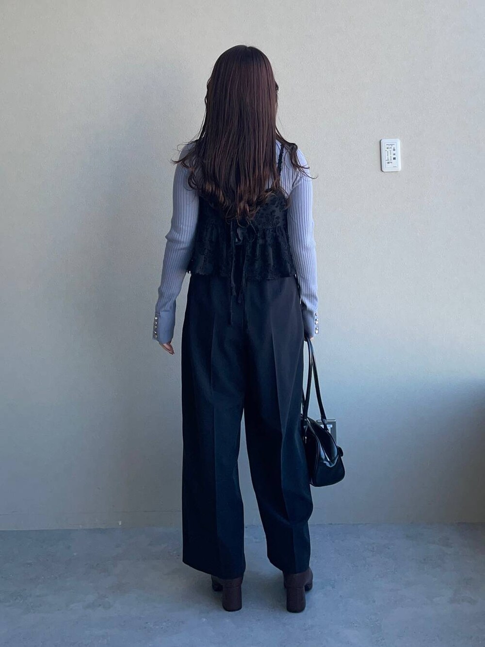 ブラウン系のブーツ、ブルー系のニット/セーター、ブラック系のその他パンツを着用したレディースの冬コーディネートの2枚目の写真