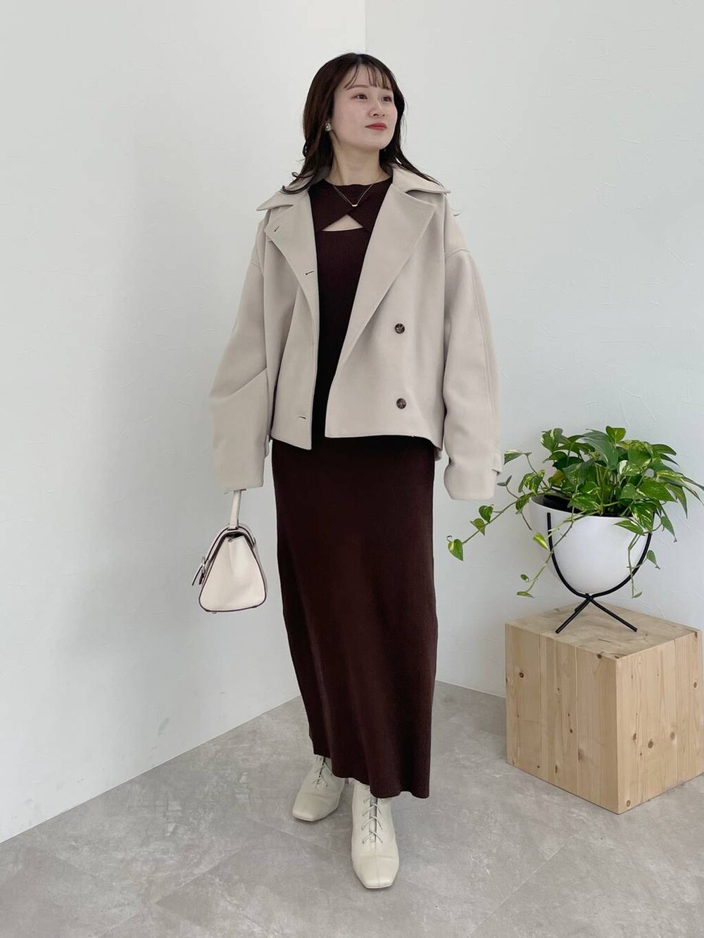 ホワイト系のその他アウター、ホワイト系のハンドバッグ、ホワイト系のブーツを着用したレディースの冬コーディネートの5枚目の写真