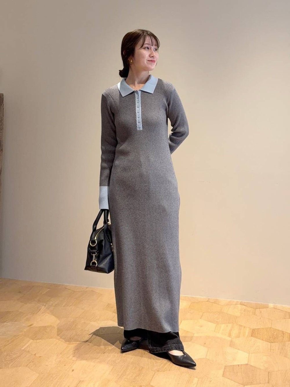 ブラック系のボストンバッグ、グレー系のワンピース、ブラック系のデニムパンツを着用したレディースの冬コーディネートの3枚目の写真