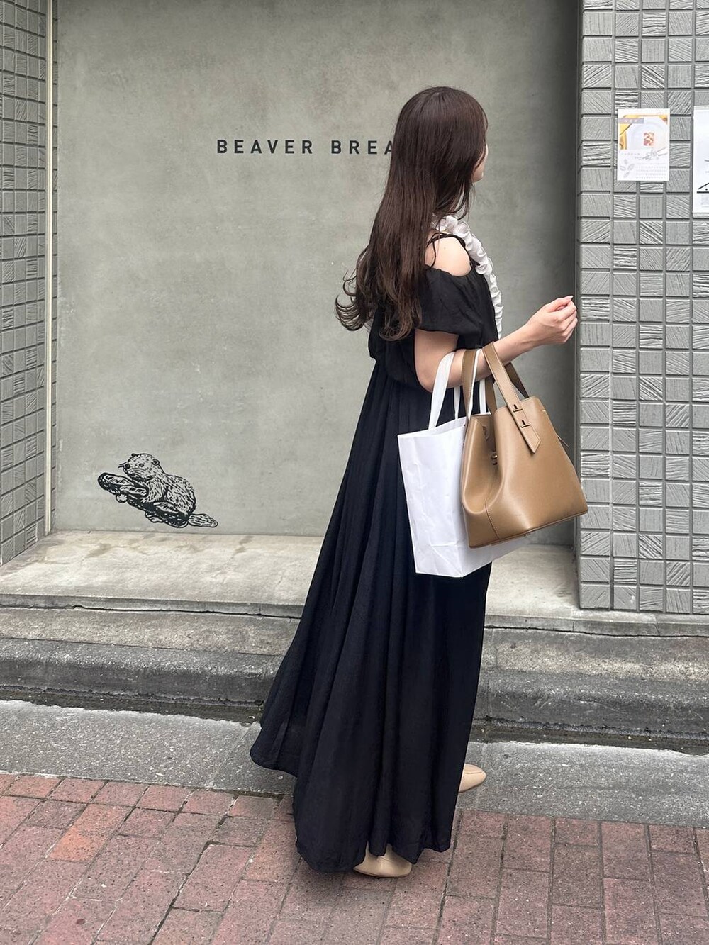 ブラック系のワンピース、グレー系のスマホグッズを着用したレディースの夏コーディネートの4枚目の写真