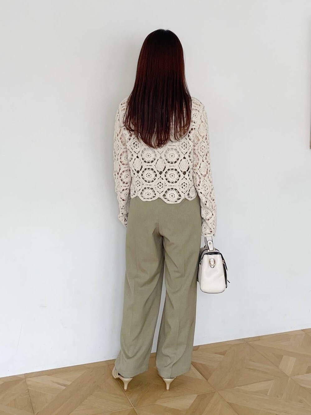 ベージュ系のスラックス、ゴールド系のパンプス、ホワイト系のカーディガン/ボレロを着用したレディースの夏コーディネートの2枚目の写真