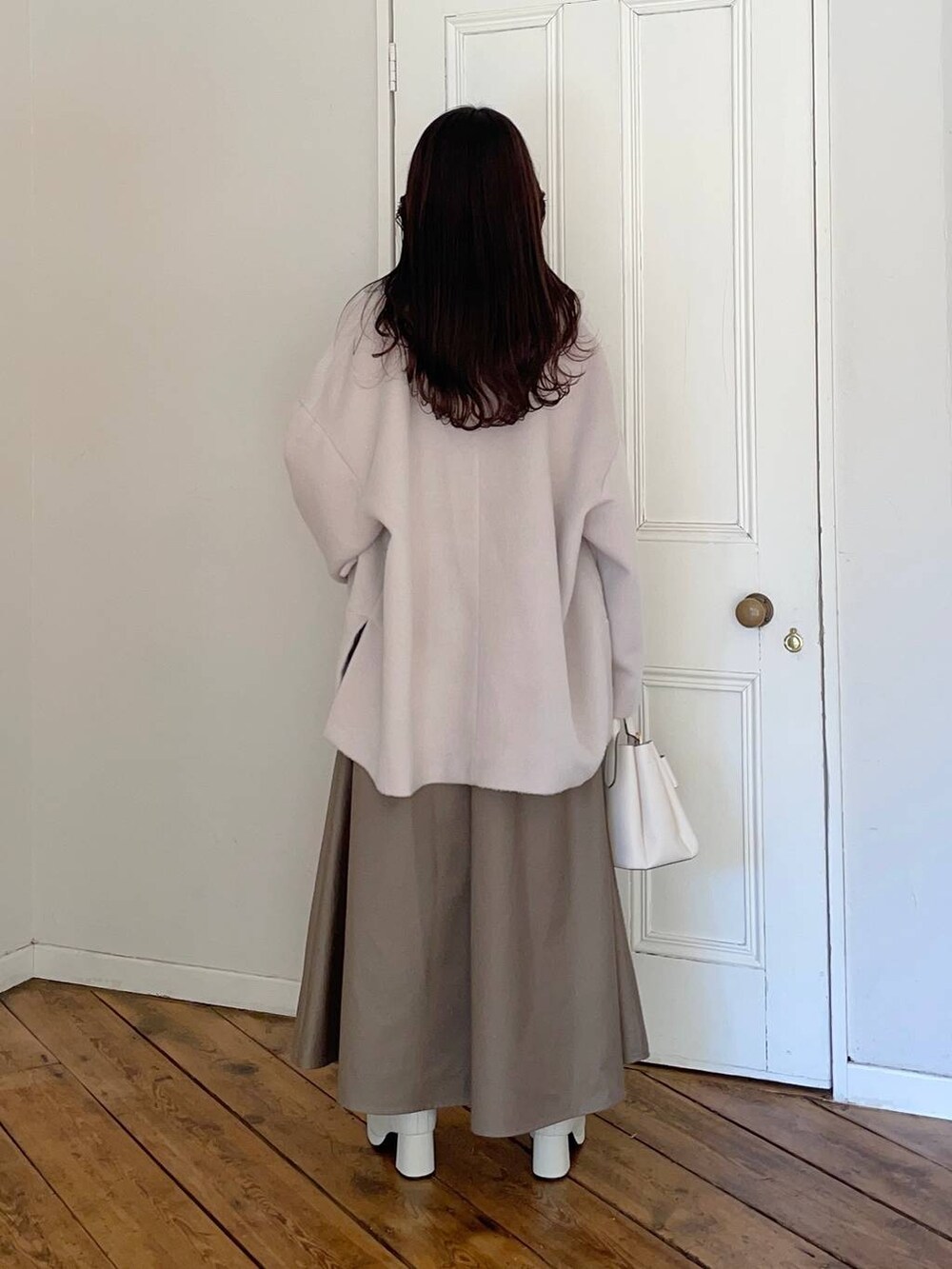 ホワイト系のブーツ、ホワイト系のショルダーバッグ、ホワイト系のテーラードジャケットを着用したレディースの冬コーディネートの2枚目の写真