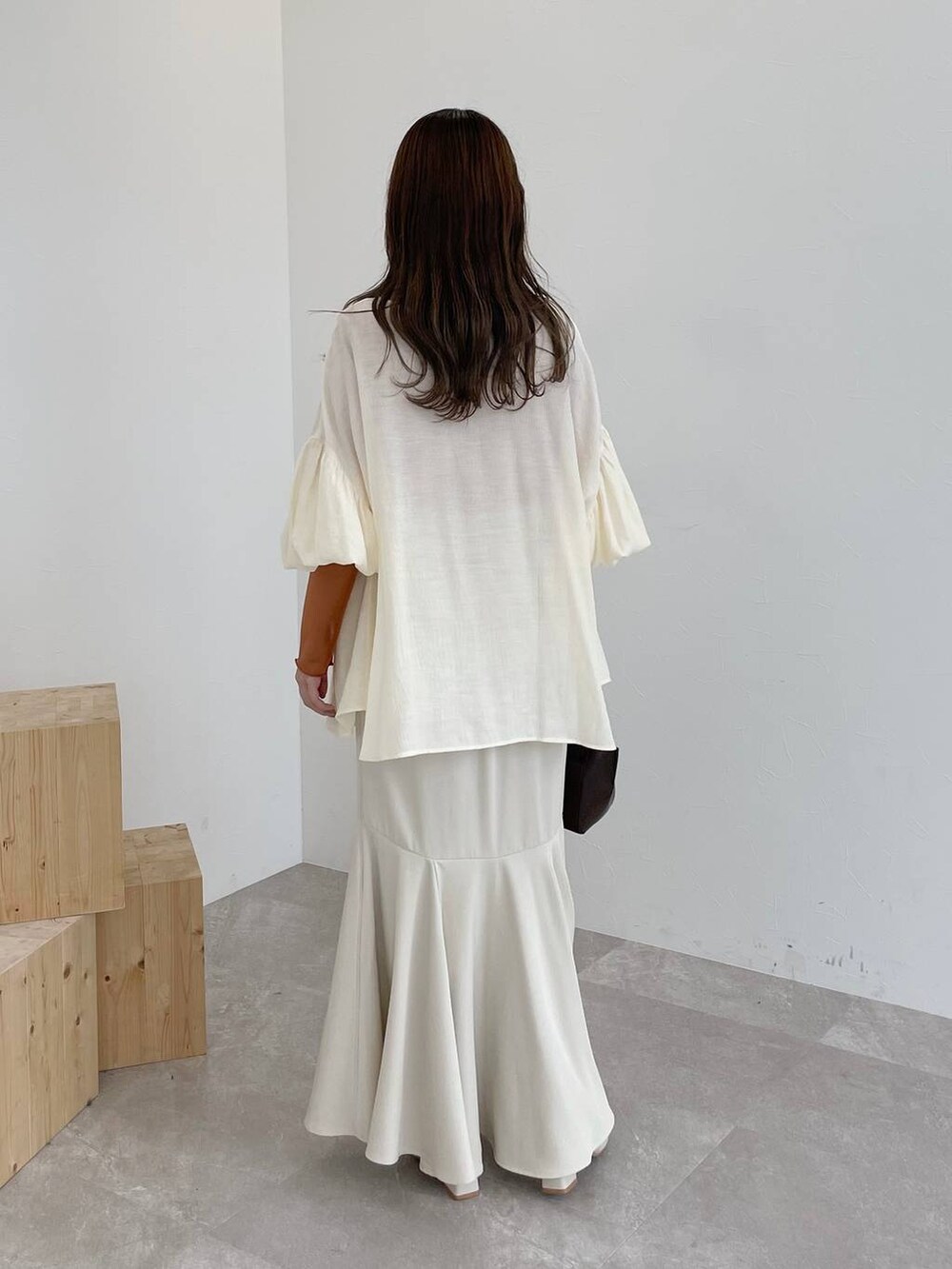 ブラウン系のハンドバッグ、ホワイト系のシャツ/ブラウス、ホワイト系のスカートを着用したレディースの夏コーディネートの3枚目の写真