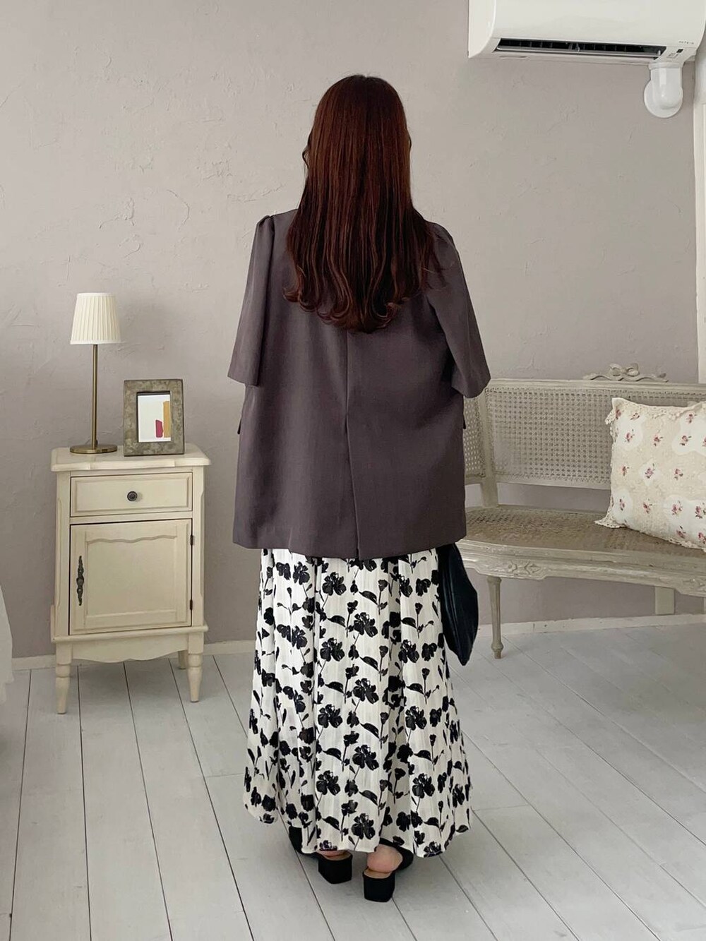 ブラウン系のテーラードジャケット、ブラック系のサンダル、ホワイト系のワンピースを着用したレディースの夏コーディネートの2枚目の写真