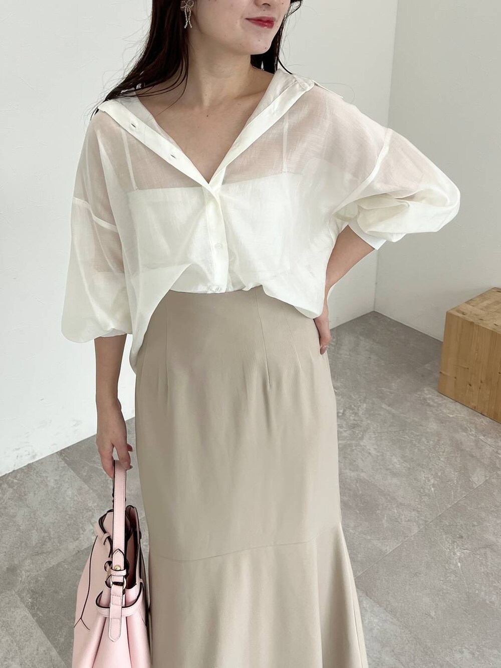 ピンク系のショルダーバッグ、ホワイト系のシャツ/ブラウス、ベージュ系のスカートを着用したレディースの夏コーディネートの3枚目の写真