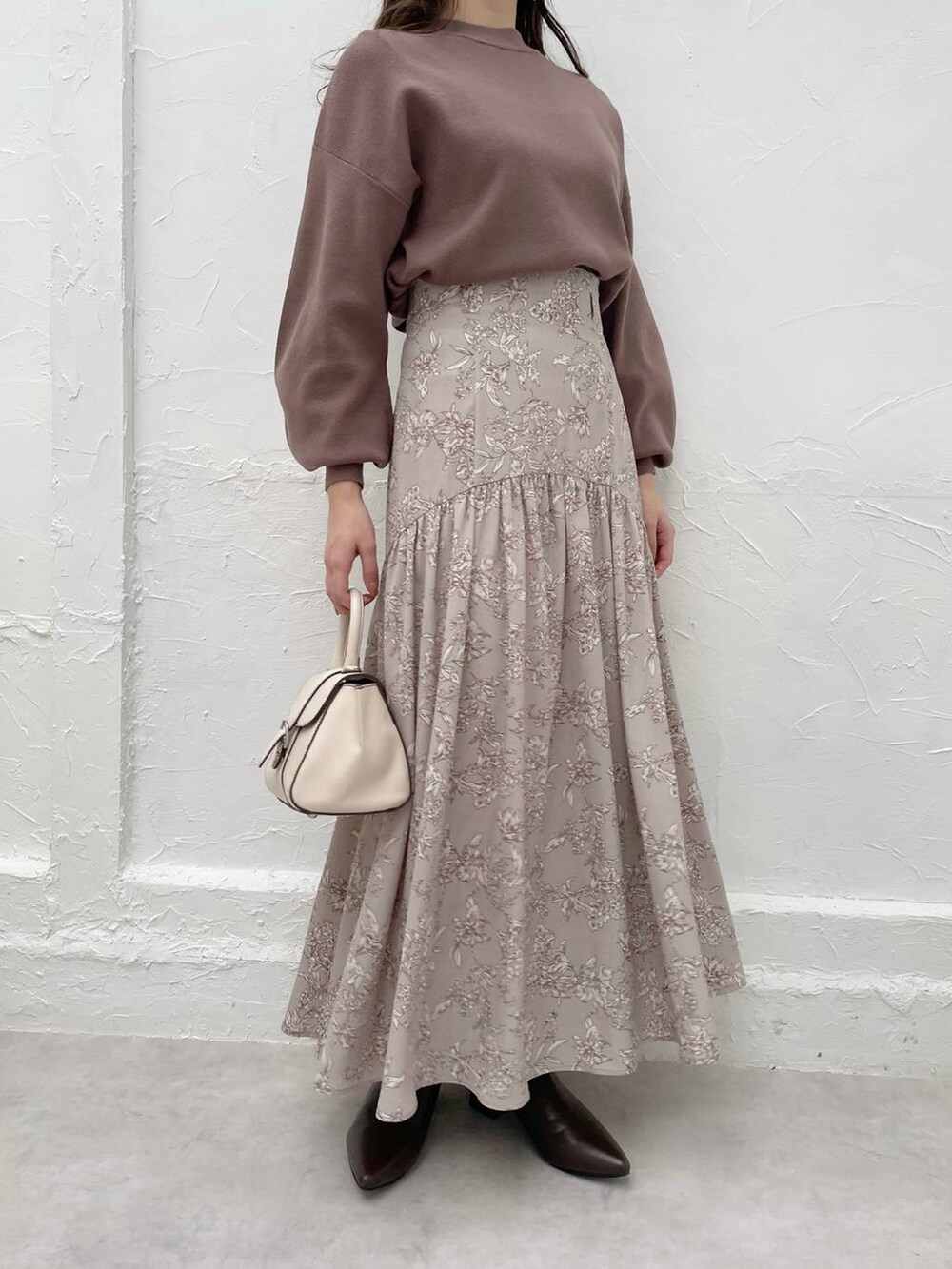 ホワイト系のハンドバッグ、ブラウン系のニット/セーター、ブラウン系のブーツを着用したレディースの冬コーディネートの4枚目の写真