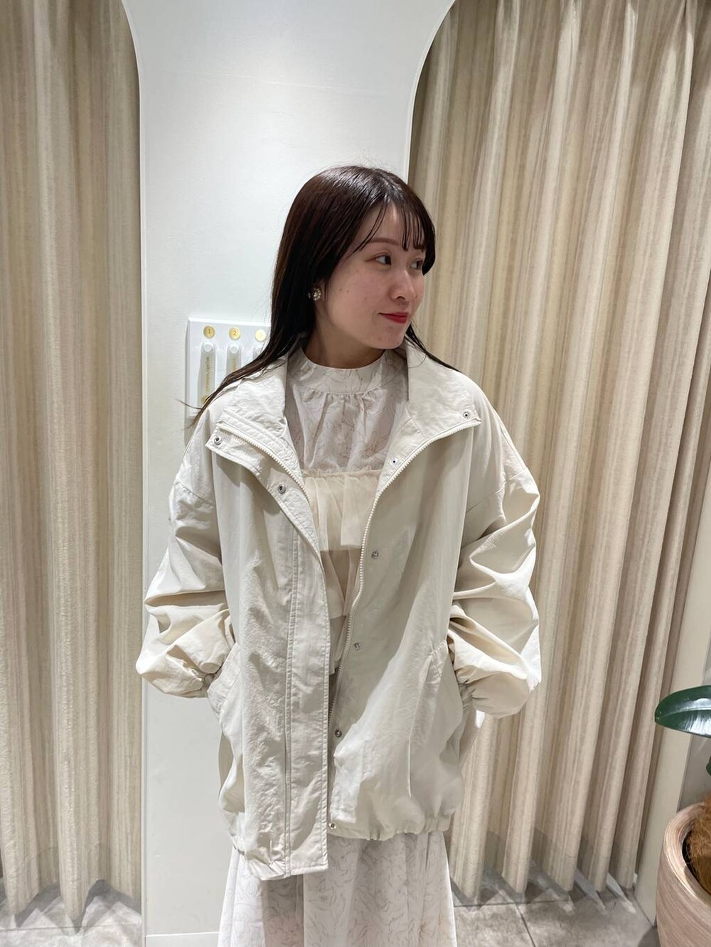 ホワイト系のブーツ、ベージュ系のワンピース、ホワイト系のブルゾンを着用したレディースの冬コーディネートの3枚目の写真