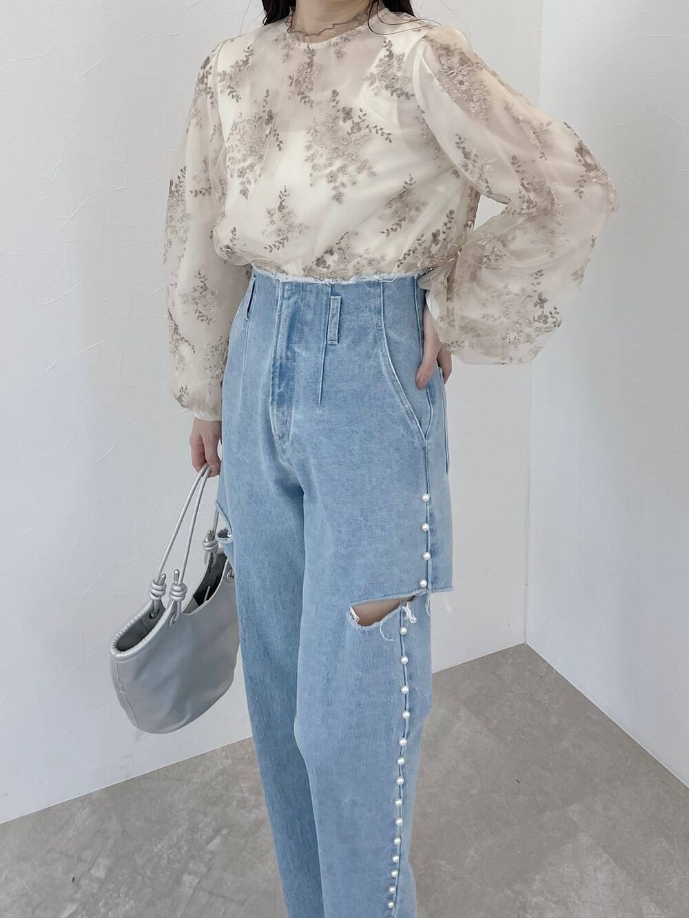 ホワイト系のシャツ/ブラウス、シルバー系のハンドバッグ、ホワイト系のブーツを着用したレディースの冬コーディネートの6枚目の写真