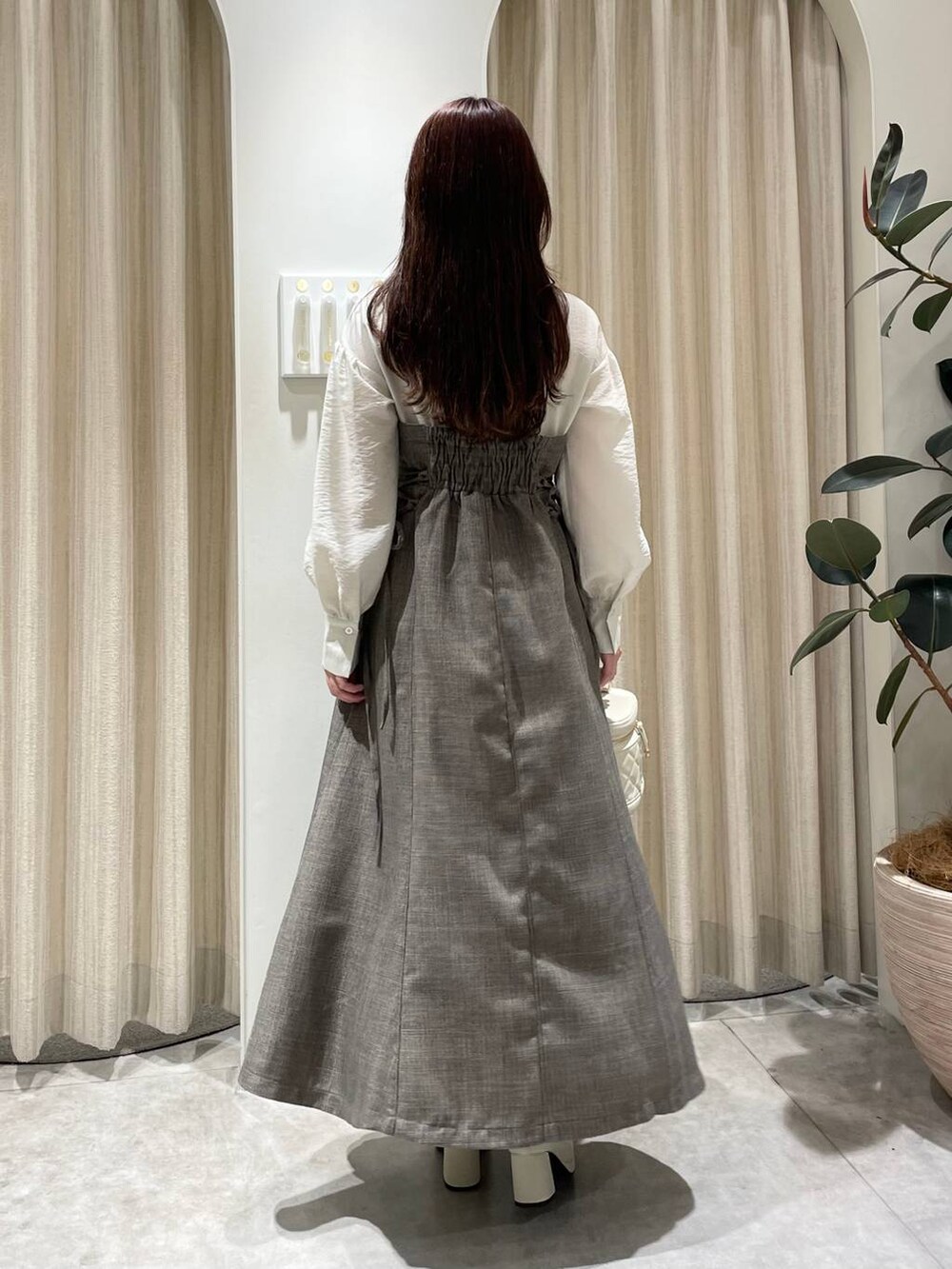 ホワイト系のブーツ、ブラウン系のワンピース、ホワイト系のショルダーバッグを着用したレディースの秋コーディネートの2枚目の写真