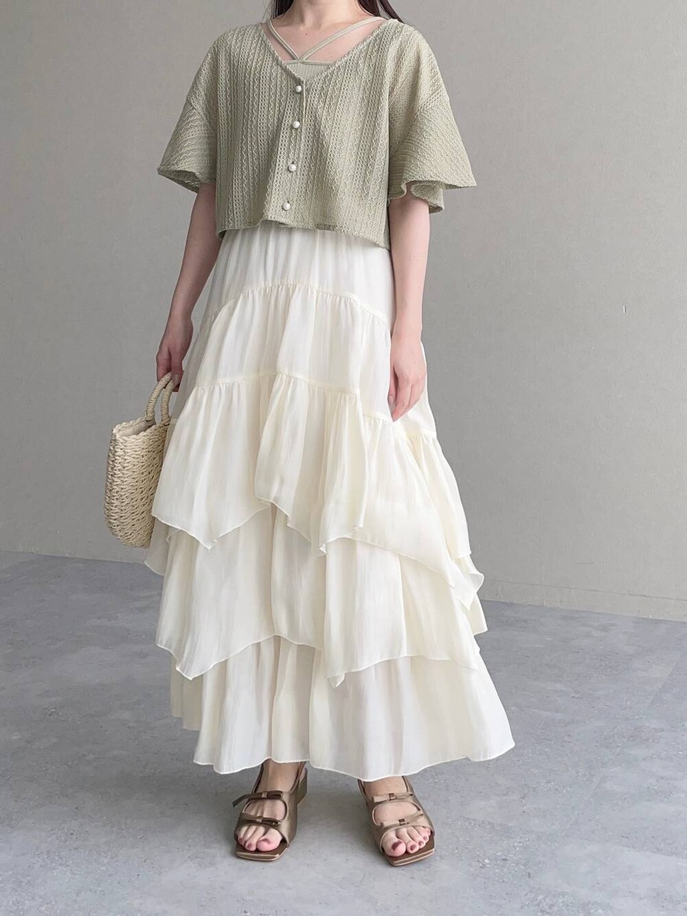 グリーン系のカーディガン/ボレロ、ブラウン系のサンダル、ホワイト系のスカートを着用したレディースの夏コーディネートの4枚目の写真