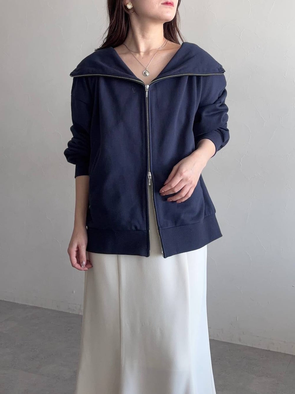 ブラック系のローファー、ブルー系のパーカー、ホワイト系のスカートを着用したレディースの冬コーディネートの3枚目の写真