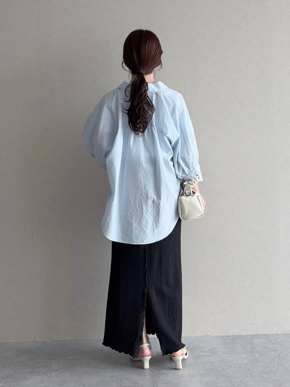 ブラック系のスカート、ブルー系のシャツ/ブラウス、ホワイト系のサンダルを着用したレディースの夏コーディネートの2枚目の写真