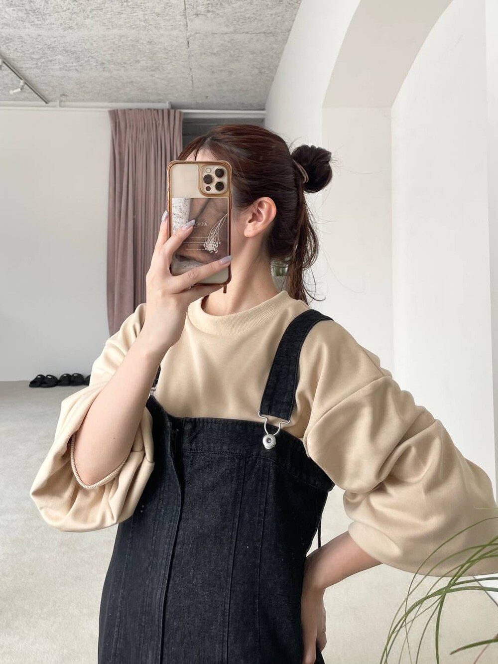 ブラック系のジャンパースカート、ベージュ系のショルダーバッグ、ブラウン系のブーツを着用したレディースの秋コーディネートの4枚目の写真