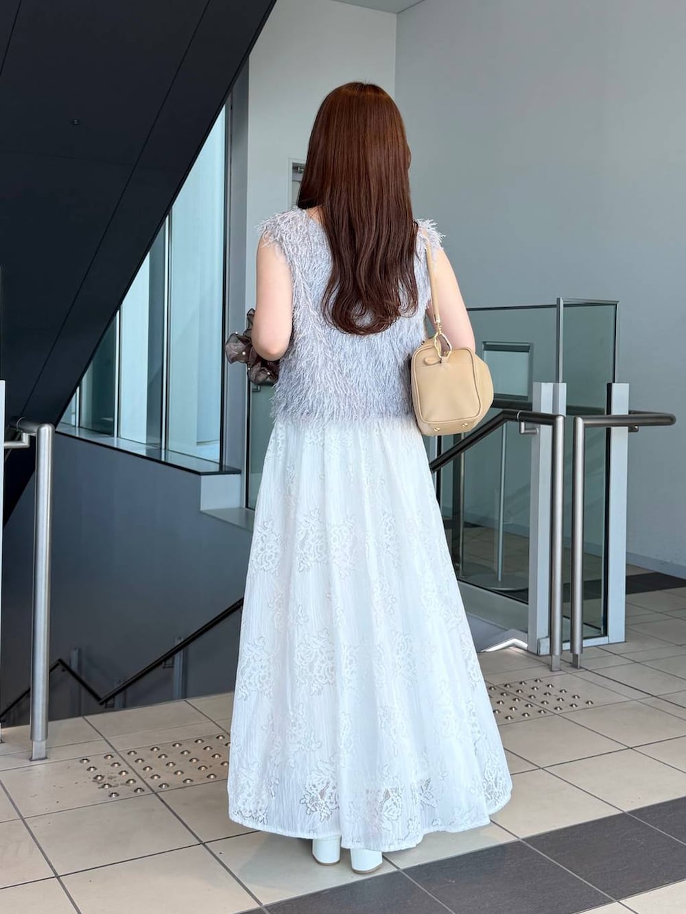 ホワイト系のワンピース、グレー系のベスト、ホワイト系のサンダルを着用したレディースの夏コーディネートの2枚目の写真