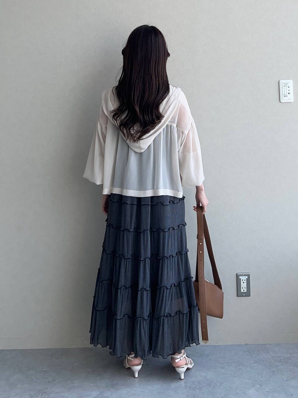 ブラウン系のショルダーバッグ、ホワイト系のパーカー、ホワイト系のサンダルを着用したレディースの夏コーディネートの2枚目の写真