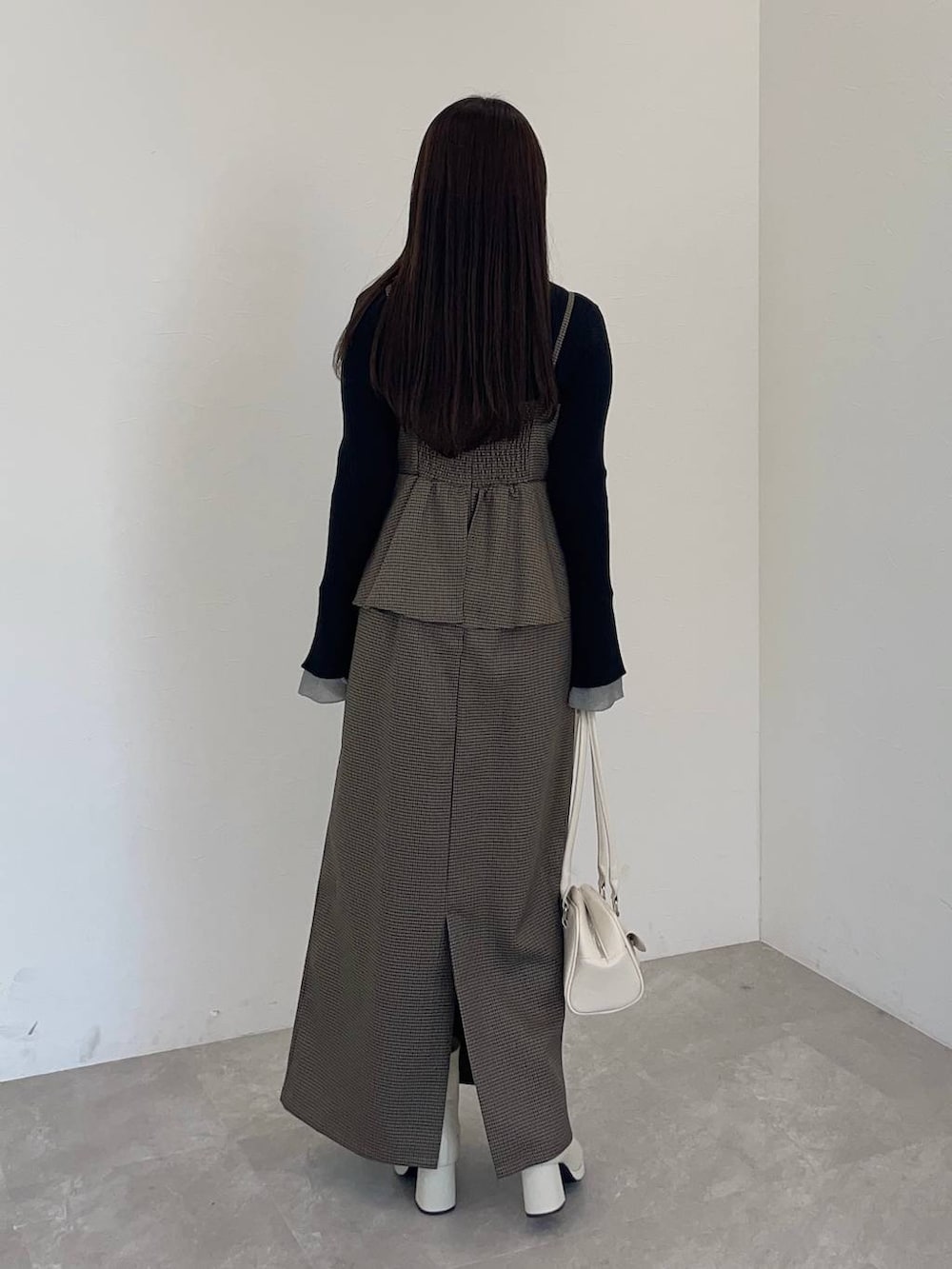 ホワイト系のブーツ、ブラウン系のワンピース、ホワイト系のハンドバッグを着用したレディースの冬コーディネートの2枚目の写真