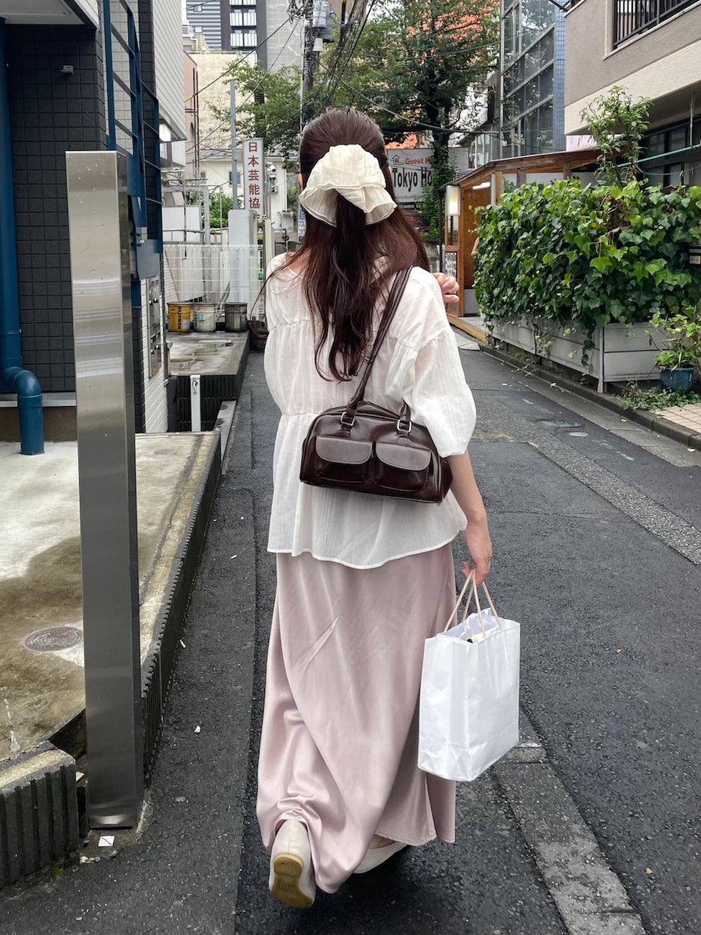 ベージュ系のスカート、ホワイト系のシャツ/ブラウス、ベージュ系のシュシュを着用したレディースの夏コーディネートの2枚目の写真