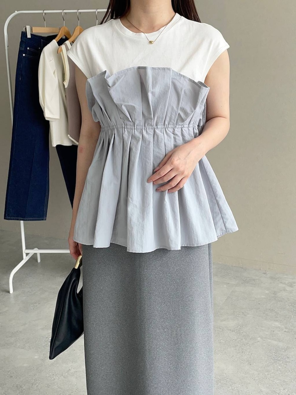 ブラック系のパンプス、ブラック系のハンドバッグ、グレー系のTシャツ/カットソーを着用したレディースの夏コーディネートの3枚目の写真