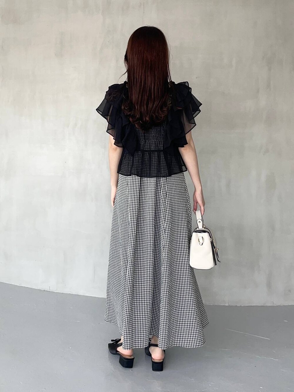 ブラック系のサンダル、ブラック系のシャツ/ブラウス、ホワイト系のショルダーバッグを着用したレディースの夏コーディネートの2枚目の写真