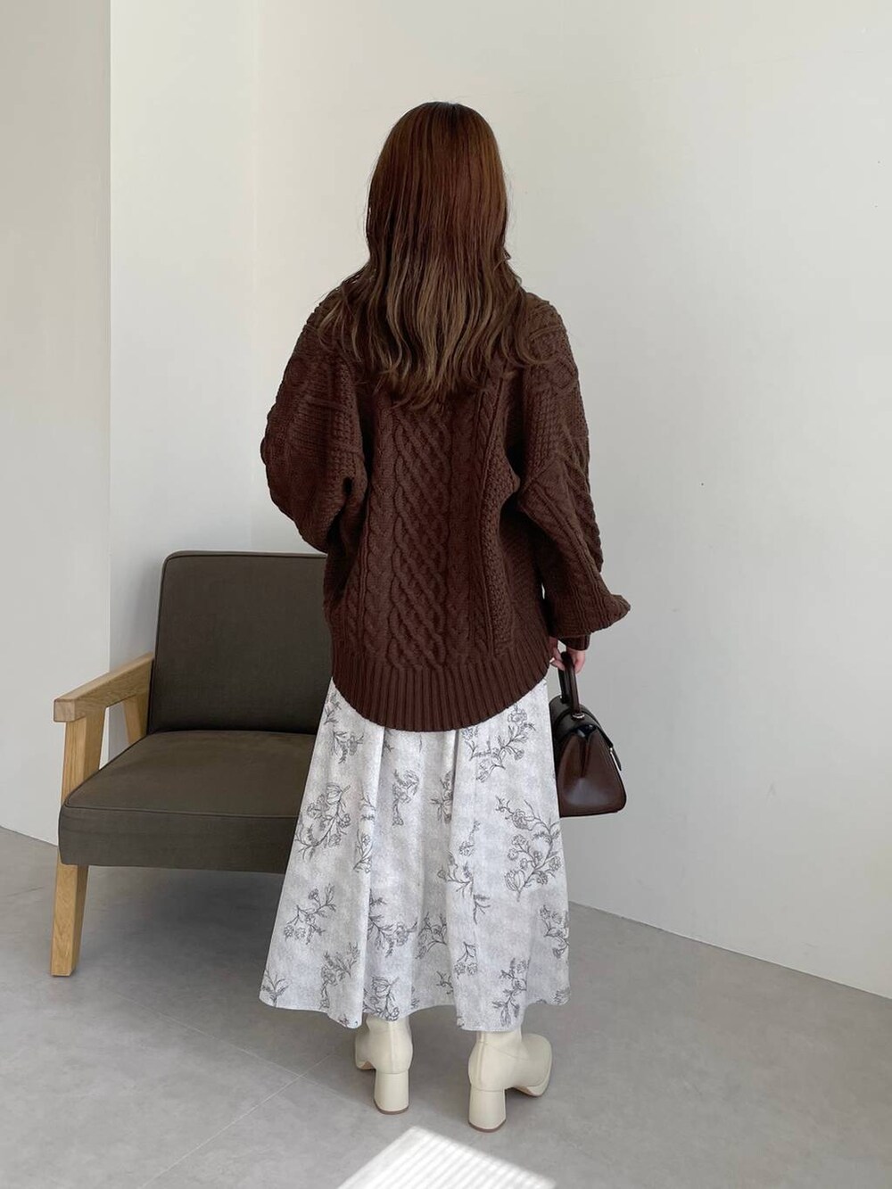 ブラウン系のハンドバッグ、ホワイト系のブーツ、ブラウン系のカーディガン/ボレロを着用したレディースの秋コーディネートの2枚目の写真