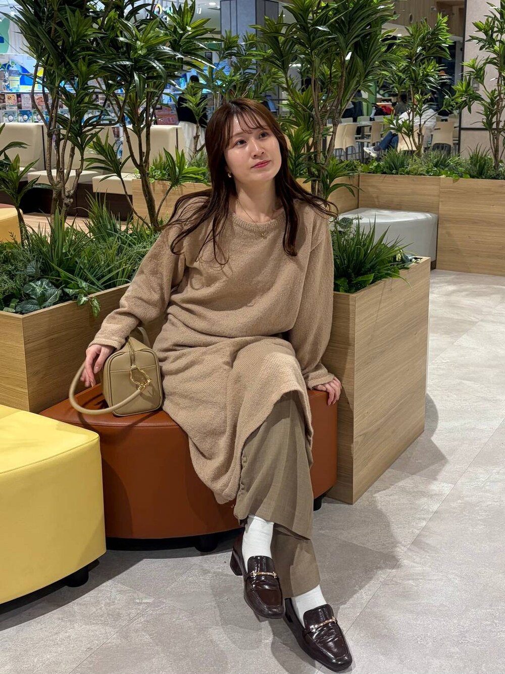 ゴールド系のボストンバッグ、ピンク系のワンピースを着用したレディースの冬コーディネートの2枚目の写真