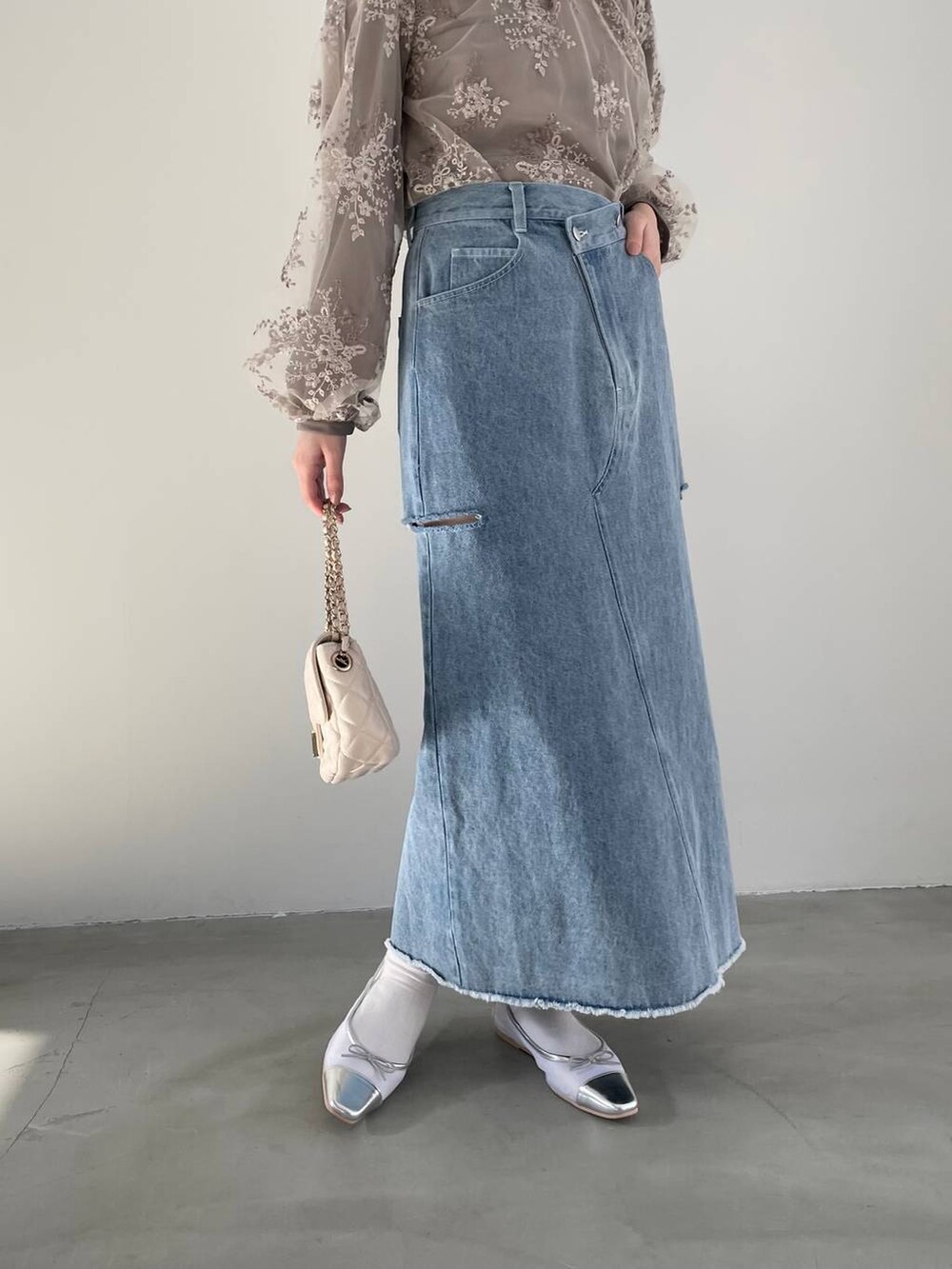 シルバー系のバレエシューズ、ブラウン系のシャツ/ブラウス、ホワイト系のショルダーバッグを着用したレディースの冬コーディネートの4枚目の写真