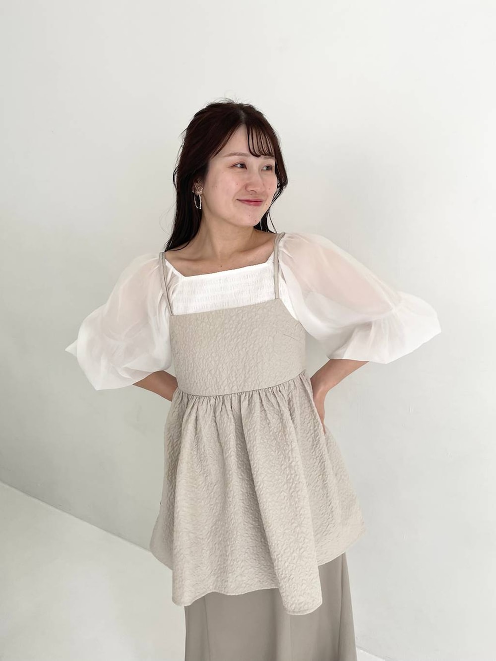 グリーン系のスカート、ホワイト系のTシャツ/カットソー、ブラック系のショルダーバッグを着用したレディースの夏コーディネートの3枚目の写真