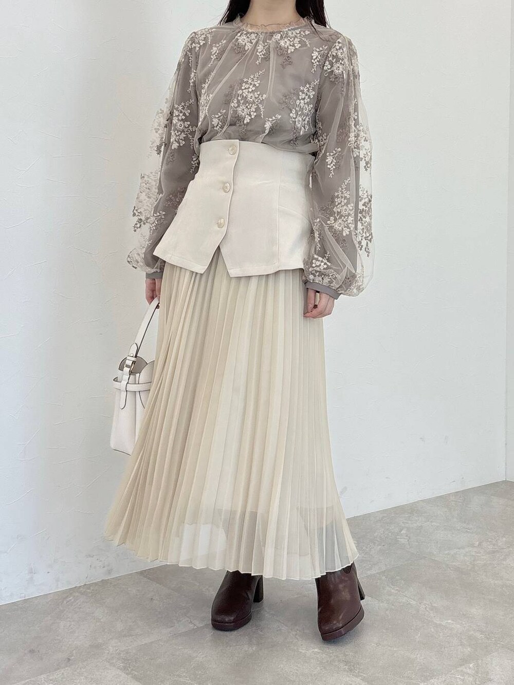 ホワイト系のショルダーバッグ、ブラウン系のシャツ/ブラウス、ブラウン系のブーツを着用したレディースの冬コーディネートの4枚目の写真