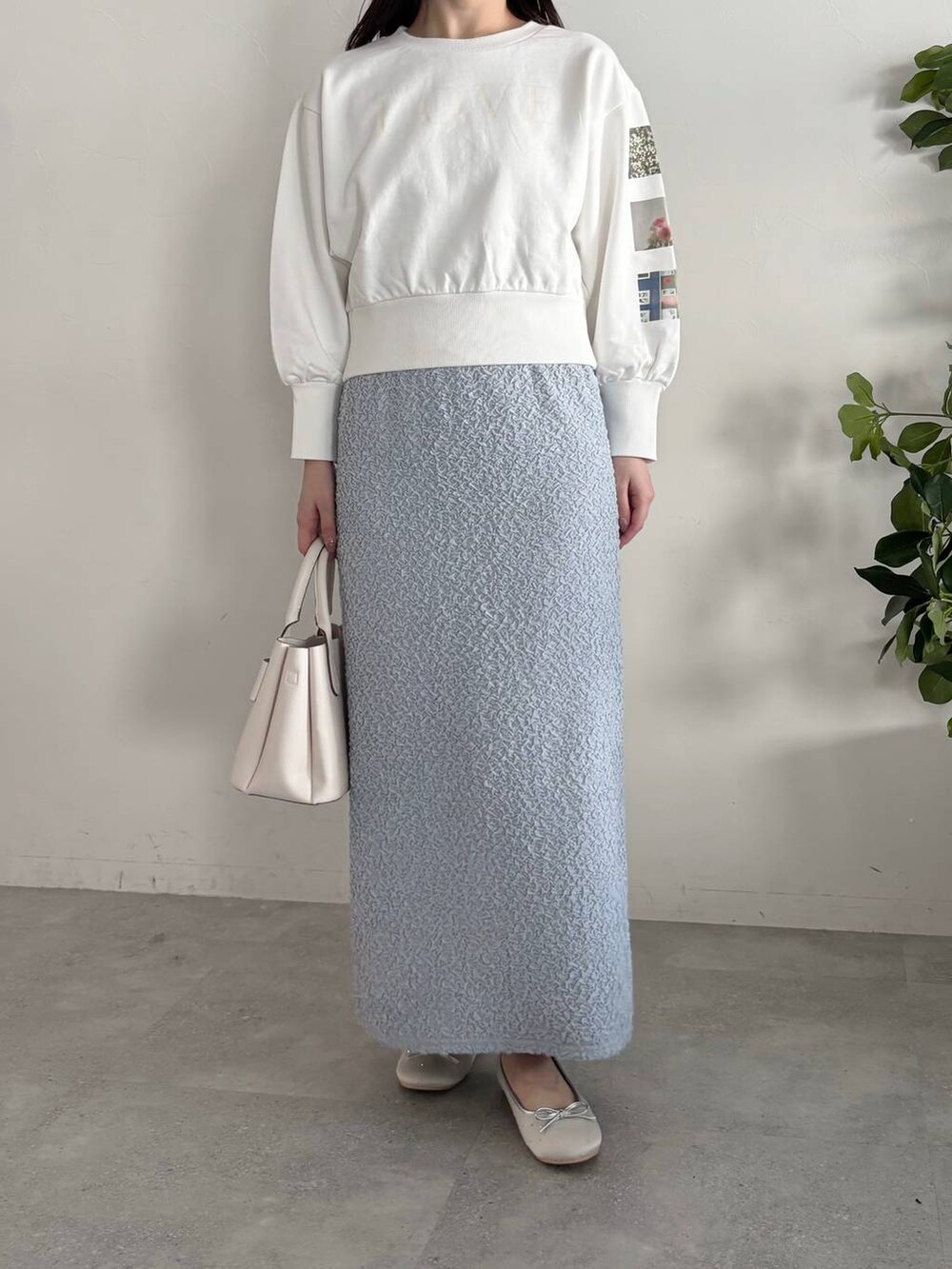 ホワイト系のショルダーバッグ、シルバー系のバレエシューズ、ブルー系のスカートを着用したレディースの春コーディネートの4枚目の写真