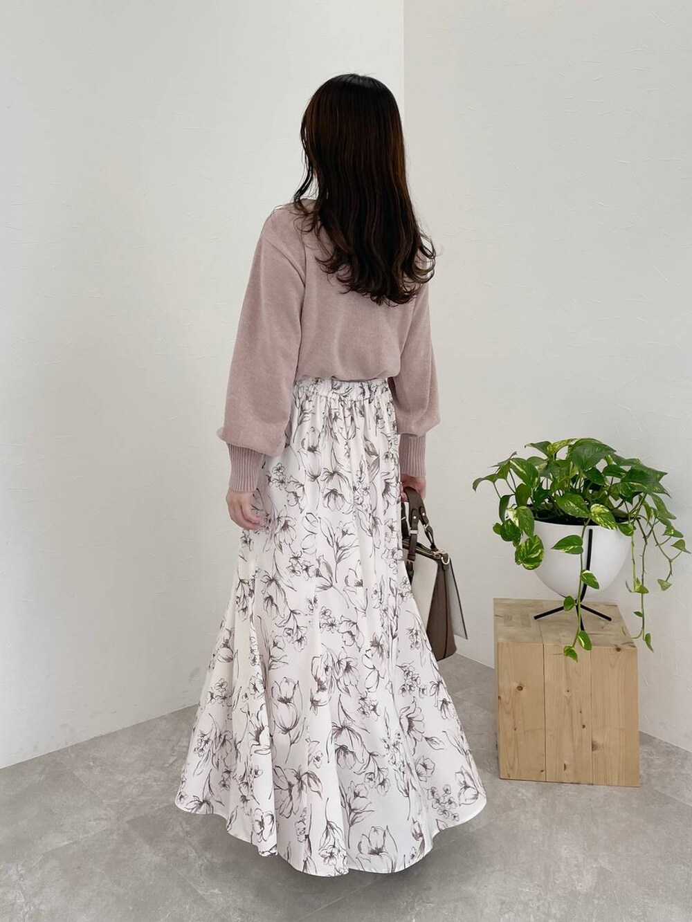 ピンク系のニット/セーター、ブラウン系のブーツ、ホワイト系のトートバッグを着用したレディースの冬コーディネートの2枚目の写真