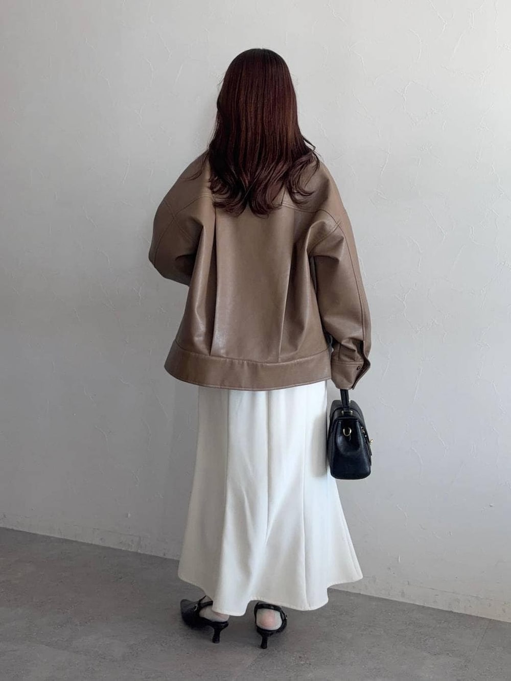 ブラック系のショルダーバッグ、ブラック系のサンダル、ブラウン系のブルゾンを着用したレディースの冬コーディネートの2枚目の写真