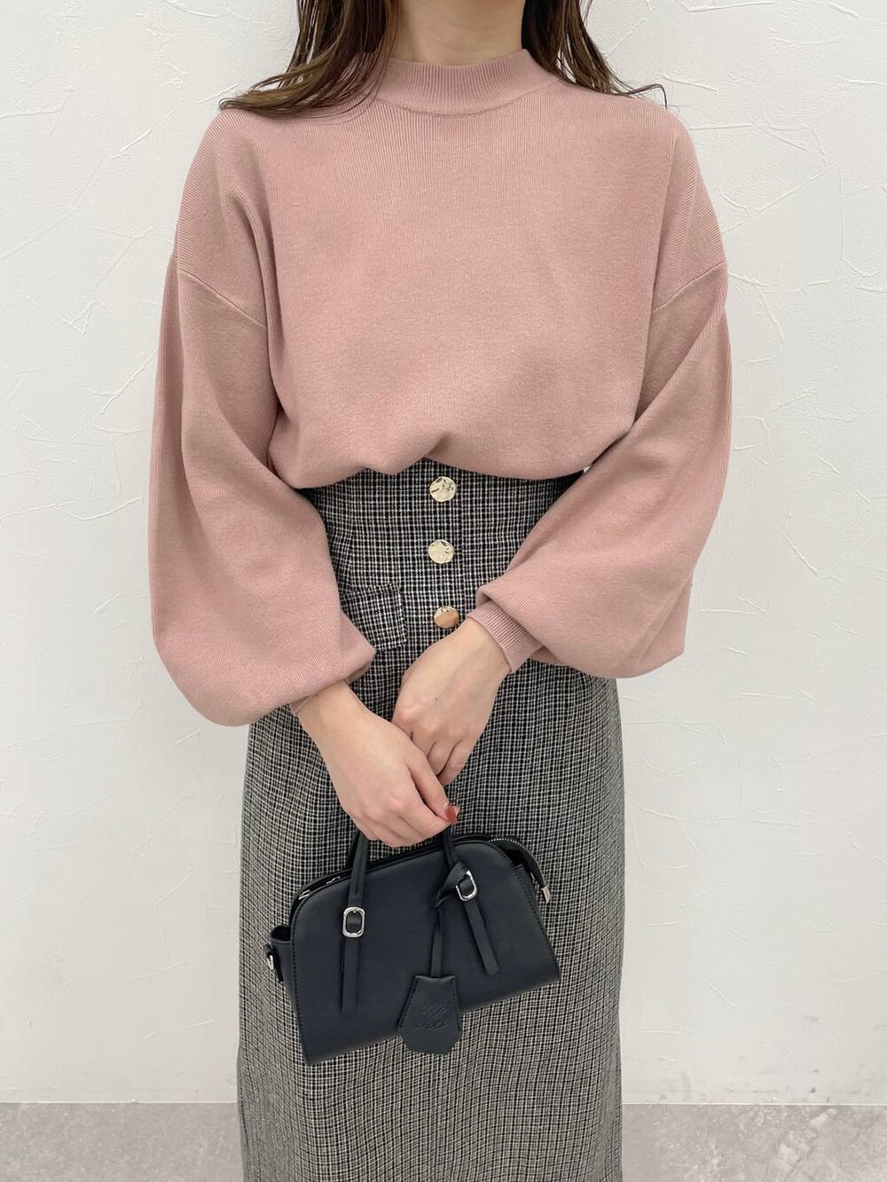 ブラック系のボストンバッグ、ホワイト系のその他シューズ、ピンク系のニット/セーターを着用したレディースの秋コーディネートの3枚目の写真