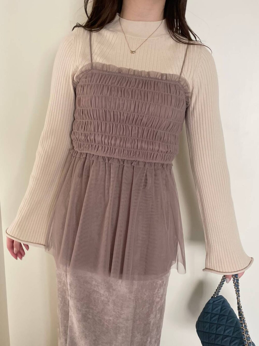 ブラウン系のスカート、ブルー系のショルダーバッグ、ホワイト系のブーツを着用したレディースの冬コーディネートの3枚目の写真