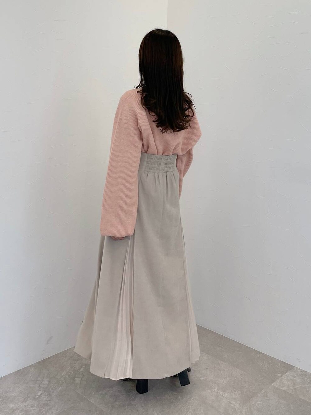 ピンク系のニット/セーター、グレー系のブーツ、ホワイト系のハンドバッグを着用したレディースの秋コーディネートの5枚目の写真