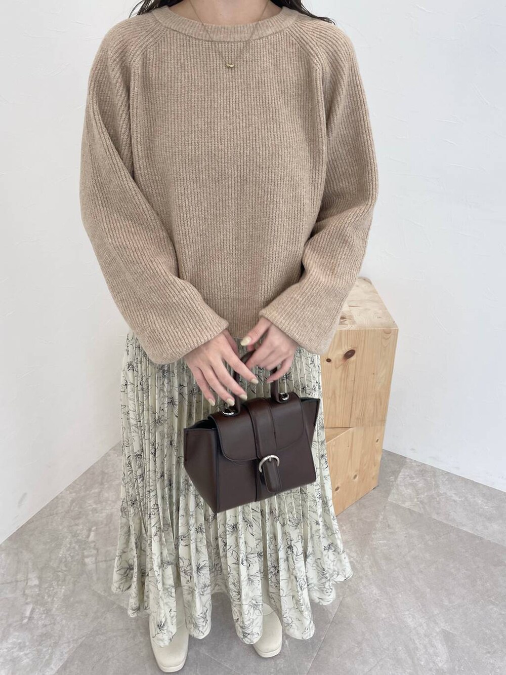 ベージュ系のニット/セーター、ブラウン系のチェスターコート、ブラウン系のハンドバッグを着用したレディースの秋コーディネートの6枚目の写真