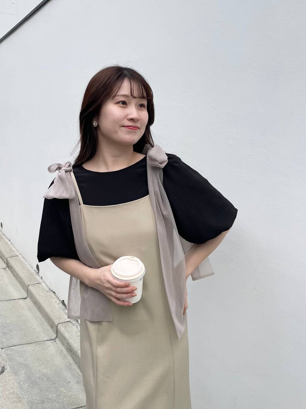 ブラック系のシャツ/ブラウス、ベージュ系のワンピースを着用したレディースの春コーディネートの4枚目の写真