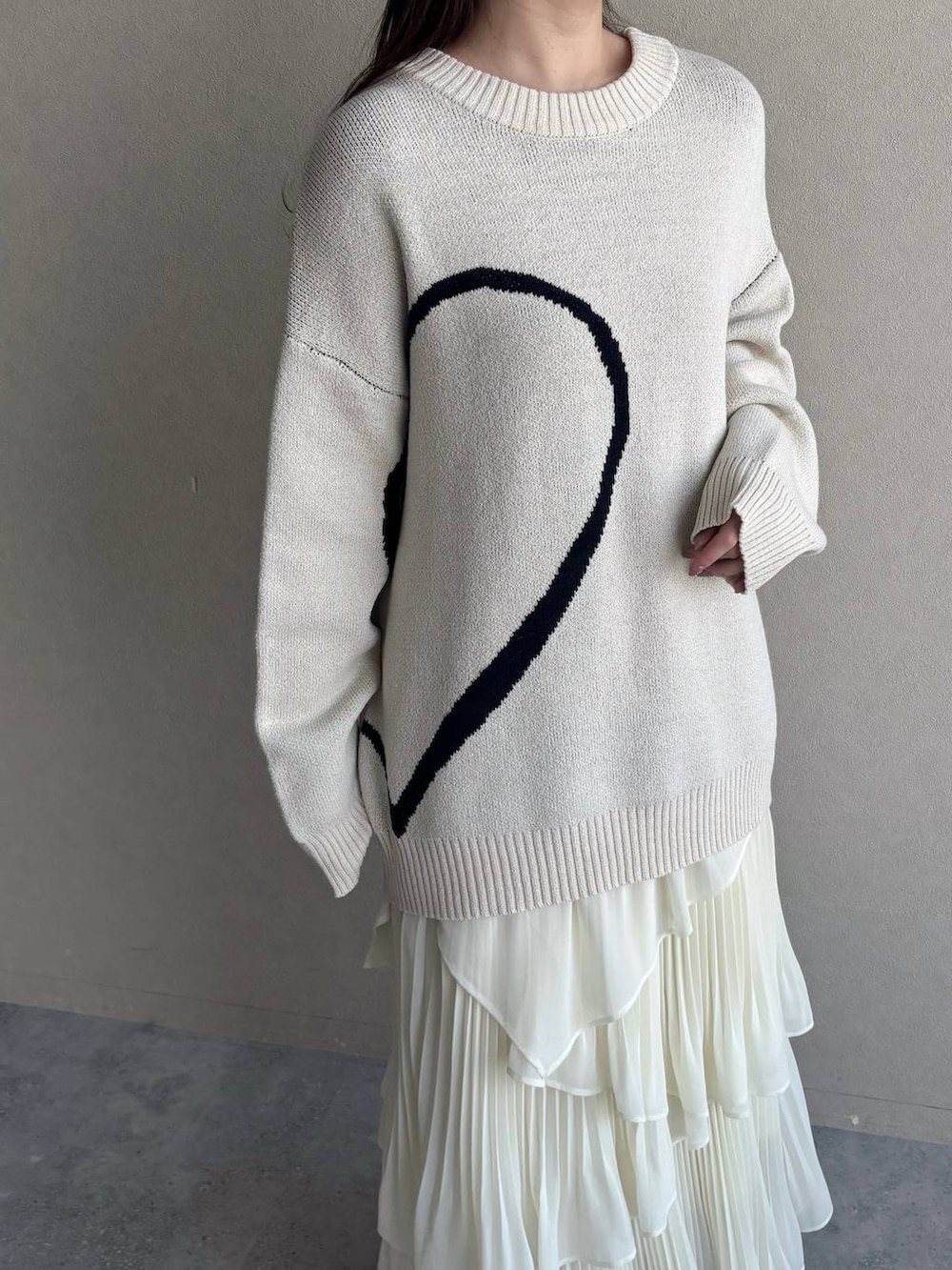 ピンク系のショルダーバッグ、ホワイト系のブーツ、ホワイト系のスカートを着用したレディースの冬コーディネートの3枚目の写真