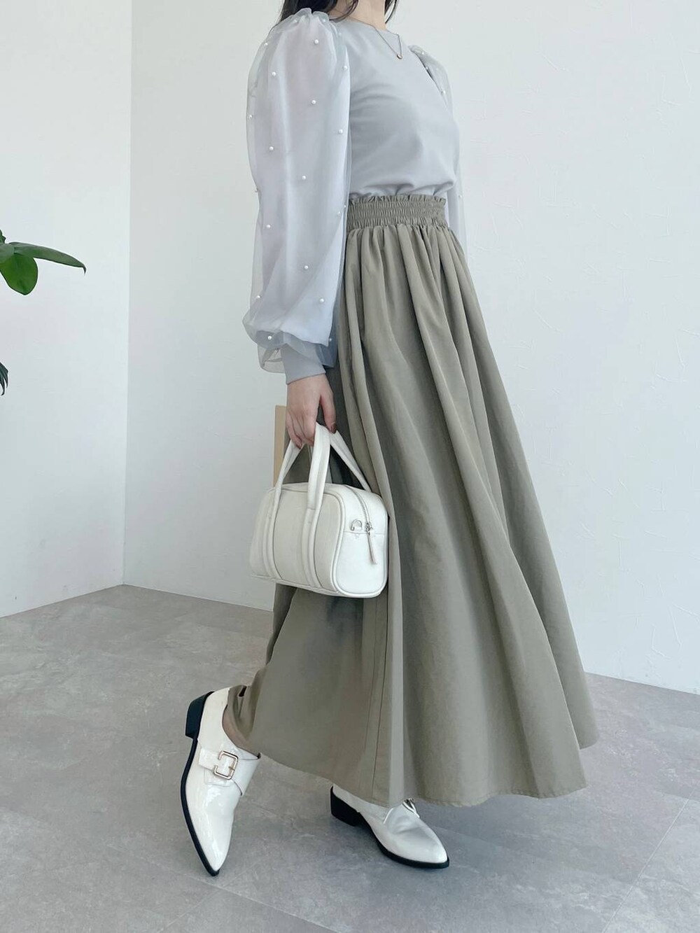ホワイト系のボストンバッグ、グレー系のTシャツ/カットソー、ベージュ系のスカートを着用したレディースの夏コーディネートの4枚目の写真