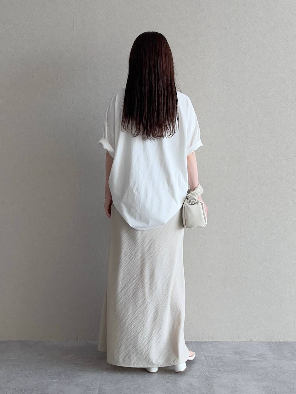 ベージュ系のスカート、ホワイト系のショルダーバッグ、ホワイト系のTシャツ/カットソーを着用したレディースの夏コーディネートの2枚目の写真