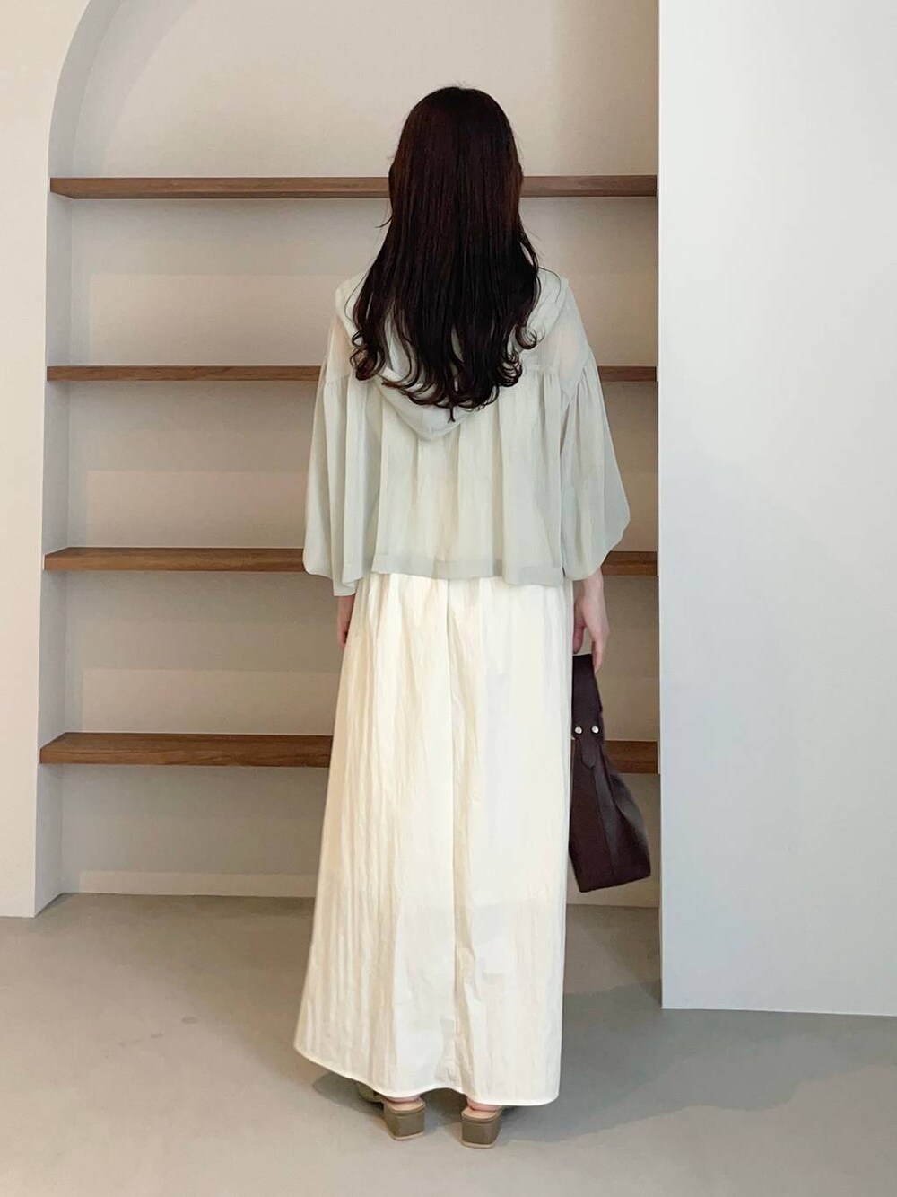 グリーン系のパーカー、ブラウン系のサンダル、ブラウン系のショルダーバッグを着用したレディースの夏コーディネートの2枚目の写真