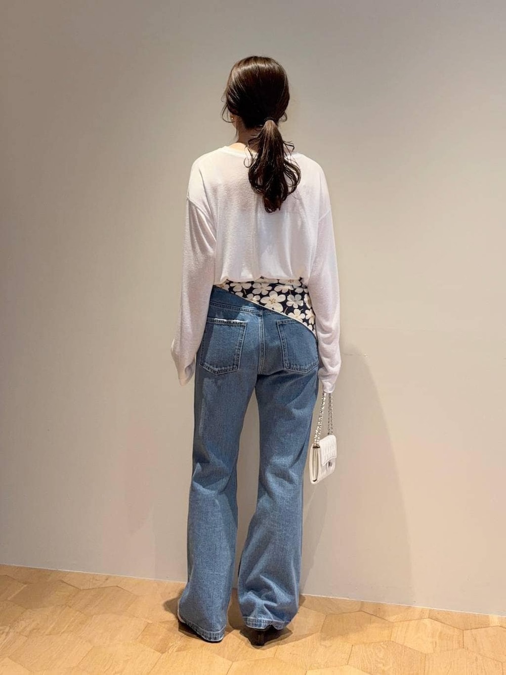 ホワイト系のTシャツ/カットソー、ブルー系のデニムパンツ、ホワイト系のサンダルを着用したレディースの春コーディネートの4枚目の写真